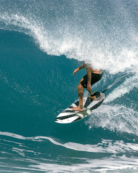 Matt surfing while wearing the 3001 Boardshort. Blue wave in background curing over Matt revealing only the bottom half of his body.