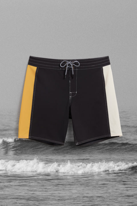 Birdie Boardshorts - Black Stripes with ocean background in black and white.