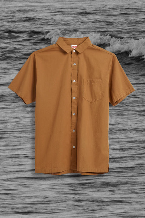 Sandpiper Shirt - Gold with ocean black and white image in background.