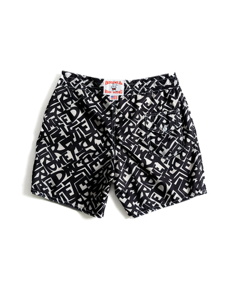 Back View of the Alphabet Soup Boardshorts. Pattern printed with black typography derived from the Birdwell logo. License Plate Label and Made in USA Label at waistband. White drawstring with white stitching. White background.