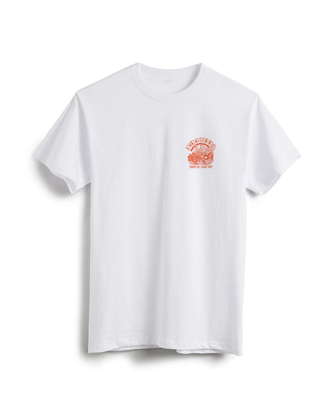 Front view of white t-shirt with small screen printed graphic on the left chest. Screen print depicts Birdie in a vintage race car with large back wheels with smoke coming out. Birdwell is written above in an outlined Slab Serif font. 