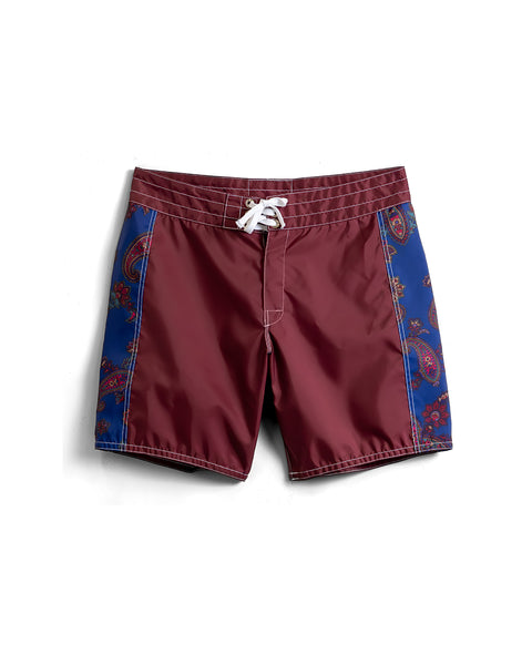 Front of 300 Boardshorts in Burgundy with two paisley fabric panels on either side. White drawcord and white contrast stitching. Product on white background.