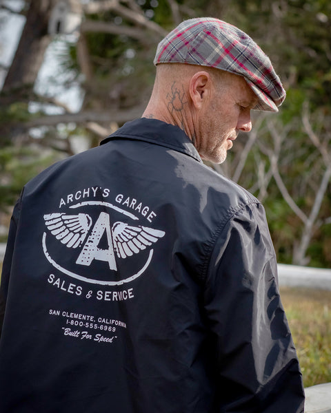 Matt Archbold wearing the the Birdwell for Archy's Garage Coach's Jacket with his back towards the camera. Back of jacket shows the Archy's Garage Logo.