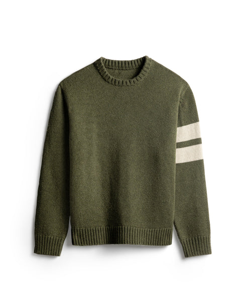 Olive colored sweater with two horizontal cream stripes on the left arm. Ribbing at collar, sleeves and bottom of sweater. White background.