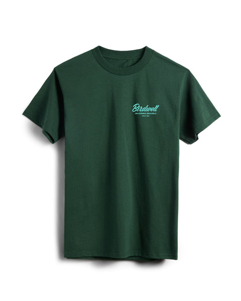 Flatlay of dark green colored t-shirt on white background. Graphic on left side of shirt with typographic treatment of Birdwell California Originals Since 1961 in a light teal color.