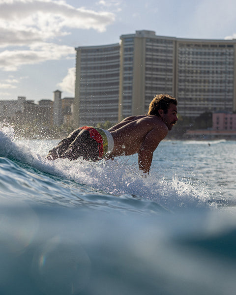 Kevin Skvarna wearing the Horizon 300 boardshorts with horizontal panels of yellow, paprika and tobacco. 