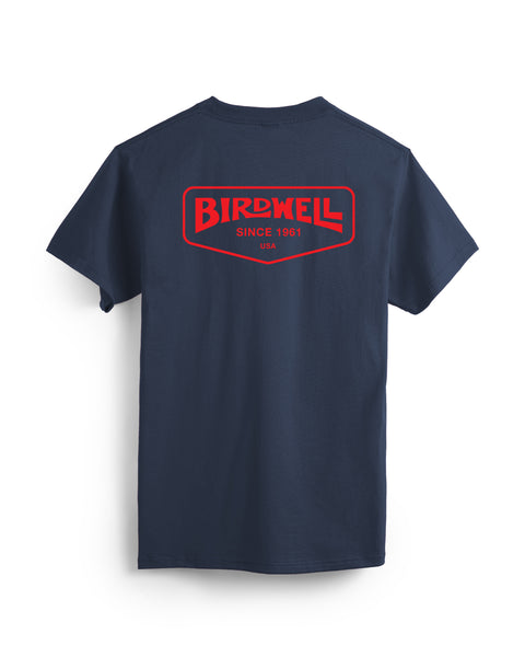 Navy Tee on White Background. Screen Printed arched Birdwell Logo with Since 1961, USA text in red surrounded by a rectangular pentagon pointing down.