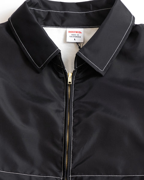 Close Up detail shot of the collar and Talon Zipper, black SurfNyl™ with white contrast stitching and white interior showing Birdwell Tag with Made in California text on the tag.