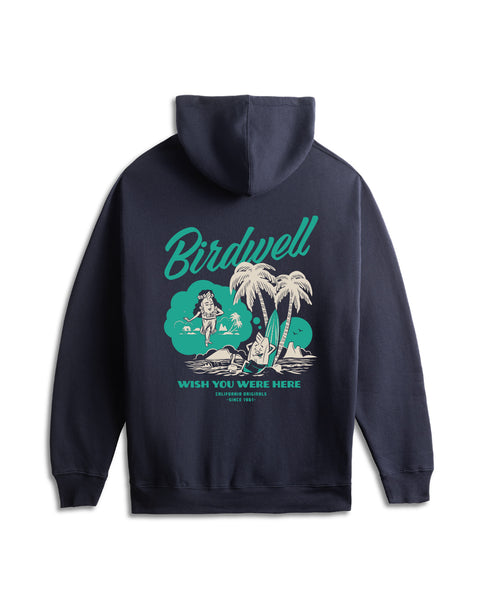 Back view of navy hoodie with screenprint illustration of our mascot Birdie leaning against a surfboard and two palm trees on the sand while dreaming of a female Birdie in a hula skirt in white and bright teal. Product on solid white background.