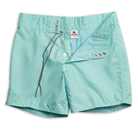 310 Boardshort in Aqua with button closures opened and drawstrings untied. Exposes the size tag that reads Made in Santa Ana and includes the California Republic Bear flag. On a white background. 